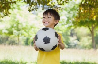 Boy with soccer ball after returning to sports after COVID-19.
