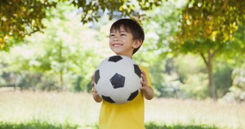 Boy with soccer ball after returning to sports after COVID-19.
