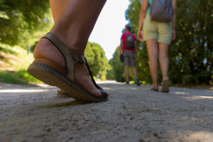 Family hiking outdoors in sandals.