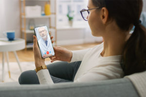 You woman in a video visit with health care provider