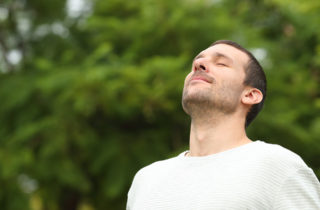 Young man with asthma practicing breathing exercises.