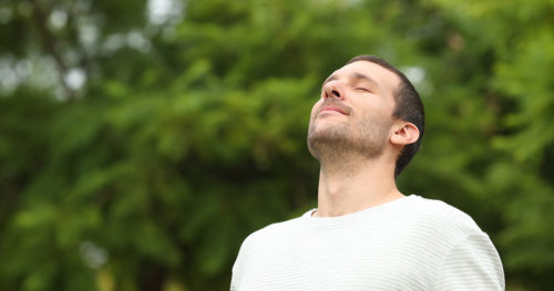 Young man with asthma practicing breathing exercises.