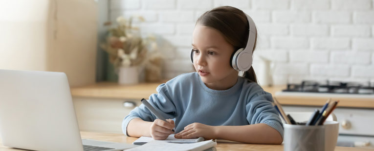 Young girl student engaged in virtual learning on laptop at home.