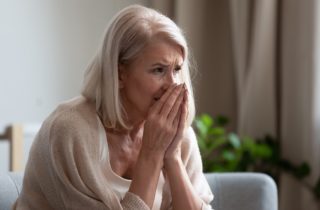 concerned senior woman holding her hands to her face