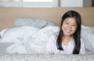 Young Asian-American girl waking up after a restful night's sleep