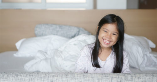 Young Asian-American girl waking up after a restful night's sleep