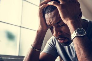 man suffers from a headache holds his hand