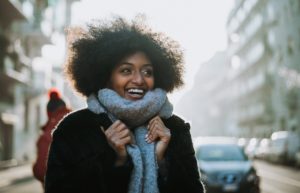 young woman with afro and scarf takes a winter walk