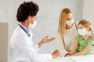 Primary Care Provider consulting a woman patient and her toddler daughter.