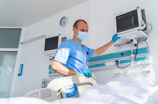 ICU nurse preparing a patient bed.