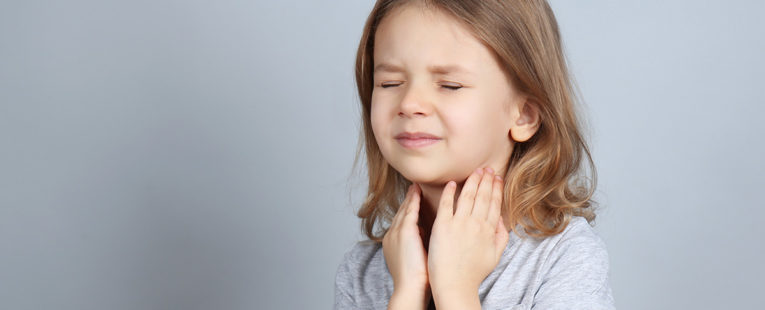 little girls holds her throat in obvious pain