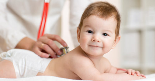 A doctor performs a newborn screening on a young baby.