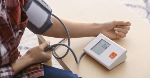 Young woman measuring his blood pressure at home