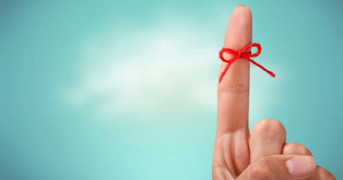 index finger with a red ribbon tied around it