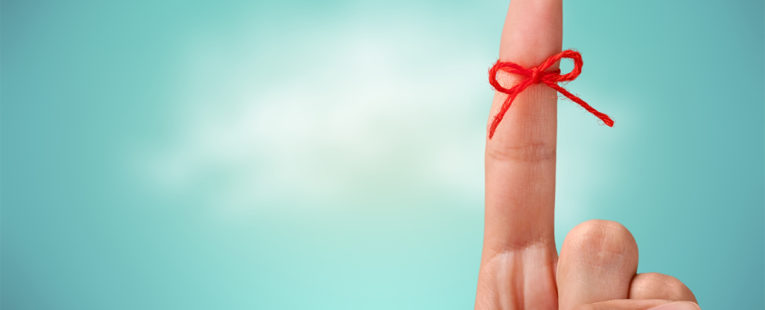 index finger with a red ribbon tied around it