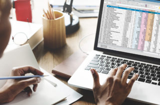 Person reviewing spreadsheet of healthcare analytics on laptop