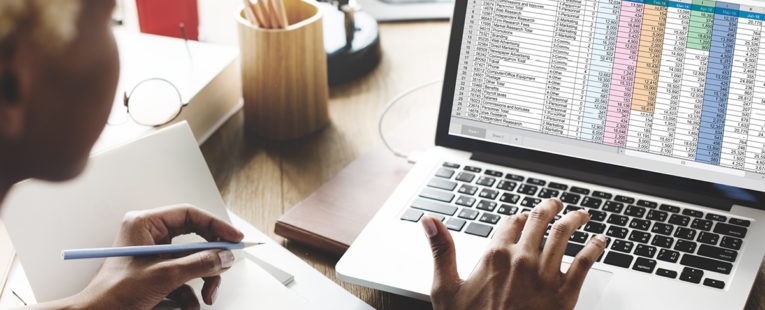 Person reviewing spreadsheet of healthcare analytics on laptop