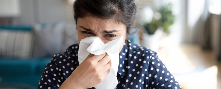 Ill, upset girl holding paper tissue blowing running nose, sneezing in handkerchief, got flu, fever, caught cold, influenza, sit at home, flu sinus, virus, disease symptom concept, face close up view