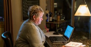 woman sitting at desk looking at computer