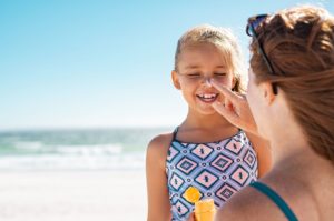 mom putting sunscreen on kid