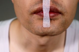 A man has taped his mouth for sleeping.