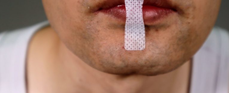 A man has taped his mouth for sleeping.