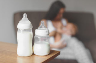 Mother with baby and baby formula or milk in bottles