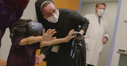 Sister Pieta and a child showcase the use of virtual reality.
