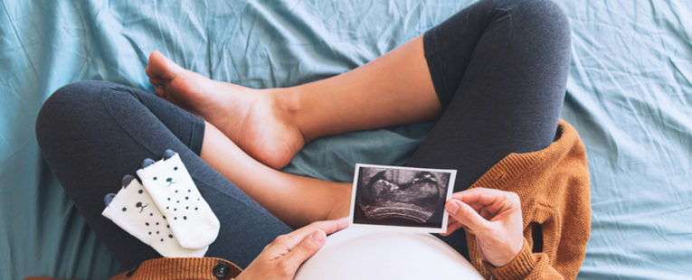 pregnant woman looking at ultrasound trimester