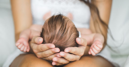 mom holding baby's head, cradle cap, infant hygiene