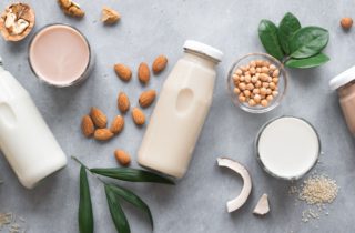 bottles of milk alternatives laid out on a table.