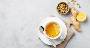 cup of tea on table with ginger and lemon.