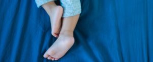 child laying down experiencing growing pains.