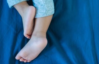 child laying down experiencing growing pains.
