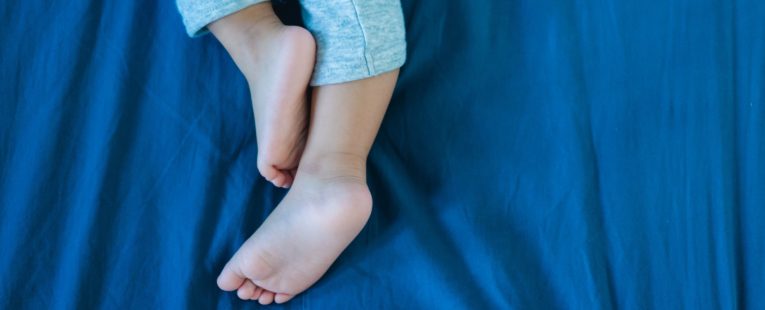child laying down experiencing growing pains.