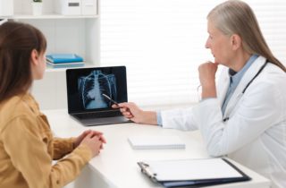 female doctor and patient review x-rays of the chest in an office
