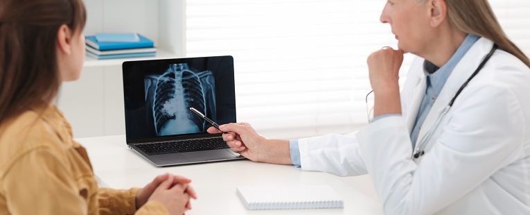 female doctor and patient review x-rays of the chest in an office